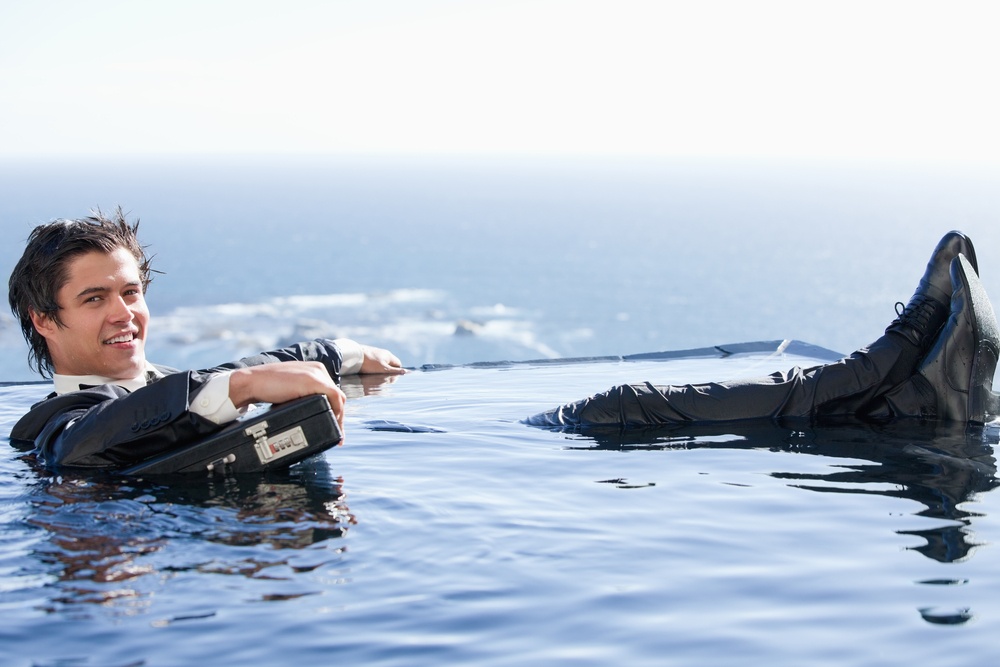 Businessman relaxing in a swimming pool in a suit